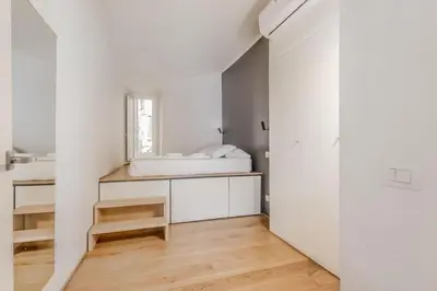 a white room with a bed and a mirror at CasaTrastevere Alessio&Simone in Rome