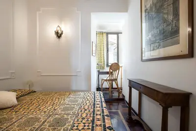 a bedroom with a bed and a table and a chair at Colosseo The Family Home in Monti in Rome