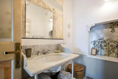 a bathroom with a sink and a mirror at Colosseo The Family Home in Monti in Rome