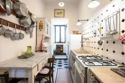 a kitchen with a stove top oven in a room at Colosseo The Family Home in Monti in Rome