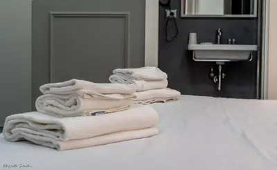 a pile of towels sitting on a counter in a bathroom at WE LOVE ROMA Guest House in Rome