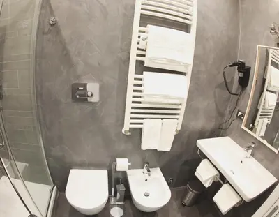 a bathroom with a toilet and a sink and a mirror at WE LOVE ROMA Guest House in Rome