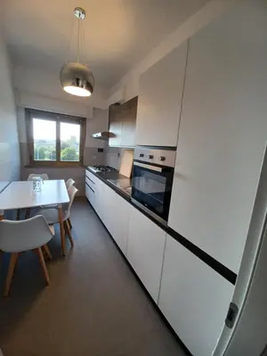 a kitchen with a table and a white refrigerator at Al posto di Luca in Rome