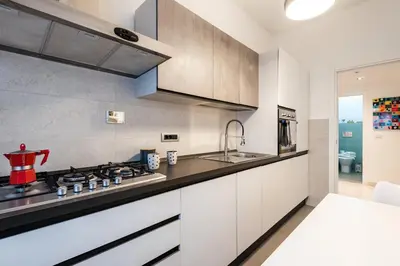 a kitchen with white cabinets and a stove top oven at Al posto di Luca in Rome
