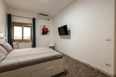 a bedroom with a bed and a tv on the wall at Al posto di Luca in Rome