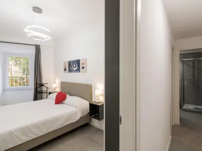 a white bedroom with a bed and a window at Apartment Welcome Rome by Interhome in Rome