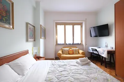 a bedroom with a bed and a chair and a desk at Guest House Piazza Tarquinia in Rome