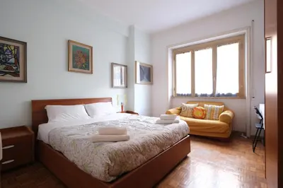 a bedroom with a large bed and a yellow couch at Guest House Piazza Tarquinia in Rome