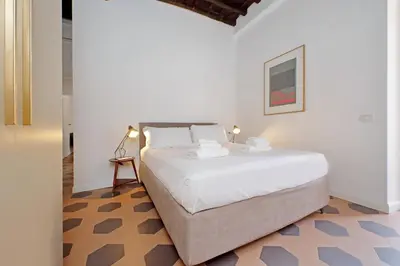 a bedroom with a large white bed in a room at Trastevere Cisterna 4 in Rome