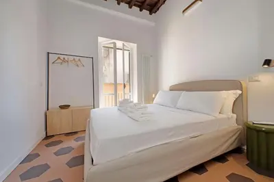 a bedroom with a large white bed in a room at Trastevere Cisterna 4 in Rome