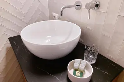 a white sink on a black counter in a bathroom at Trastevere Cisterna 4 in Rome