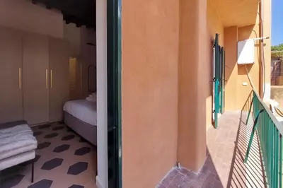 a room with a bedroom and a balcony with a bed at Trastevere Cisterna 4 in Rome