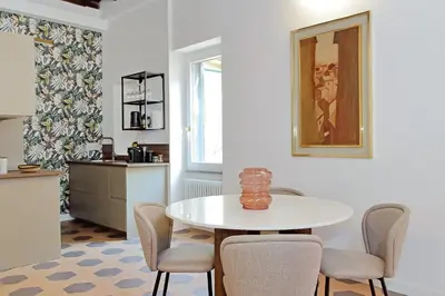 a dining room with a white table and chairs at Trastevere Cisterna 4 in Rome