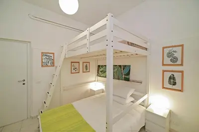 a bedroom with a white bunk bed with a ladder at Lucia Casa Vacanze Ponte Milvio in Rome