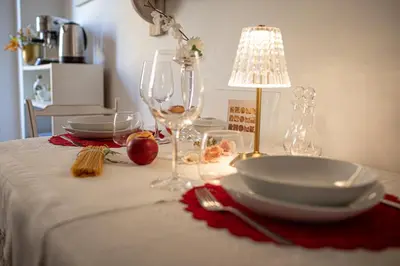 a table with wine glasses and a lamp on it at RHOME - Luxury Sharing Home in Rome