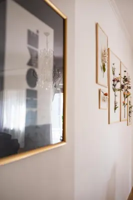 a mirror hanging on a wall with pictures on it at RHOME - Luxury Sharing Home in Rome