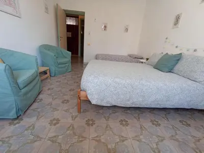 a bedroom with a bed and a couch and chairs at VerdePigna Apartment in Rome