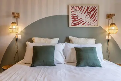 a bedroom with a white bed with three pillows at Dafne Rooms un soggiorno energico e pieno di vita in Rome