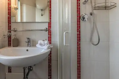 a bathroom with a sink and a shower at Dafne Rooms un soggiorno energico e pieno di vita in Rome