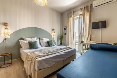 a bedroom with a large bed and a blue couch at Dafne Rooms a relaxing piece of paradise in Rome