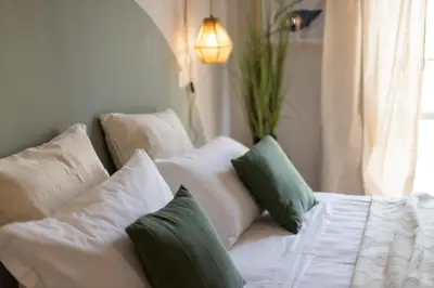 a white couch with green pillows in a room at Dafne Rooms a relaxing piece of paradise in Rome