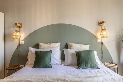 a bedroom with a bed with green and white pillows at Dafne Rooms a relaxing piece of paradise in Rome