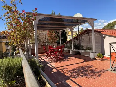 a pavilion with two red chairs on a patio at Terracehome71 - Apartment with relaxing terrace near Vatican in Rome