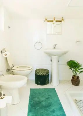 a white bathroom with a toilet and a sink at Villa Mara Appia antica in Rome