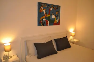 a bedroom with a bed with two lamps and a painting at Monteverde Nest in Rome