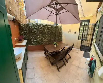 a patio with a table and an umbrella at Monteverde Nest in Rome