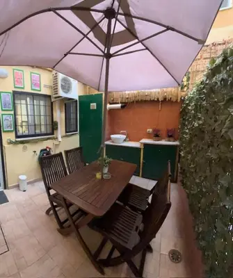a wooden table and chairs under an umbrella at Monteverde Nest in Rome