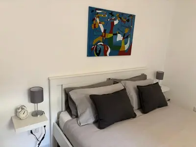 a bedroom with a bed with a painting above it at Monteverde Nest in Rome