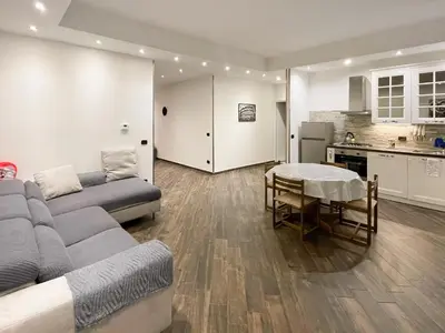 a living room with a couch and a table and a kitchen at roominrome Alexander Apartment in Rome