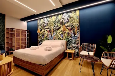 a bedroom with a bed and a painting on the wall at Eterna Suites Roma in Rome