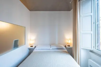 a bedroom with a bed with two lamps on two tables at My Tiny Home Alchemy in Rome