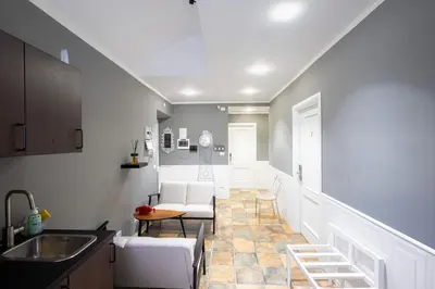 a kitchen with a sink and a living room at My Tiny Home Alchemy in Rome