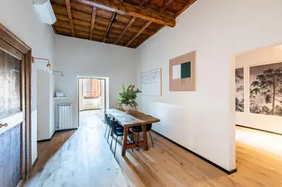 a dining room with a wooden table and a wall with paintings at ROMAC Baullari II 4bdr near Campo de Fiori in Rome