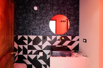 a bathroom with a black and white patterned wall at ROMAC Baullari II 4bdr near Campo de Fiori in Rome