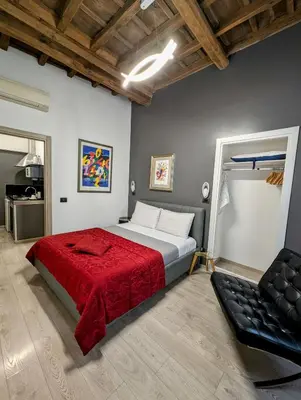 a bedroom with a large bed with a red blanket at Domus Forus in Rome