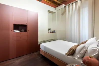a bedroom with a large bed and a cabinet at ROMAC Baullari III - Family apartment in Campo de Fiori in Rome