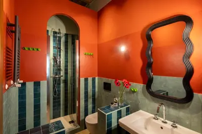 a bathroom with orange walls and a sink and a shower at ROMAC Baullari III - Family apartment in Campo de Fiori in Rome