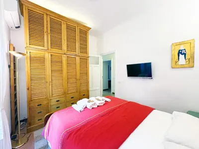 a bedroom with a large bed with a red blanket at Atelier Montecuccoli in Rome