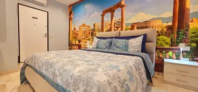 a bedroom with a bed with a painting on the wall at Il Magnifico Superior Rooms 400m from Tiburtina Railway Station and 290m from Metro in Rome