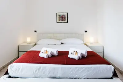 a bedroom with a large white bed with two pillows at Appartamento vista Colosseo in Rome