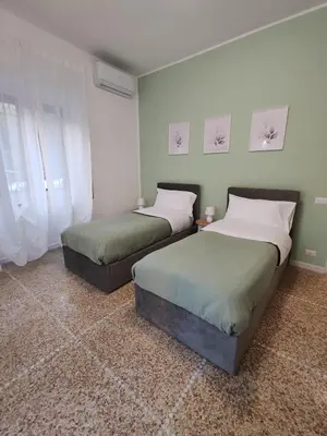 two beds sitting in a room withermottermottermott at San Pietro Green Home in Rome