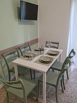a white table with chairs and wine glasses on it at San Pietro Green Home in Rome