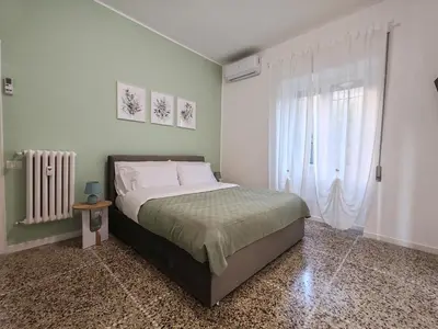 a bedroom with a bed and a large window at San Pietro Green Home in Rome