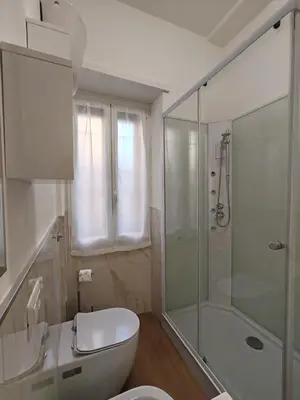 a bathroom with a toilet and a glass shower at San Pietro Green Home in Rome