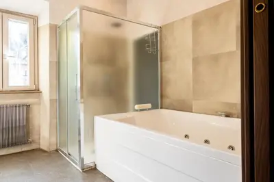 a bathroom with a tub and a glass shower at Caffarella Suite in Rome