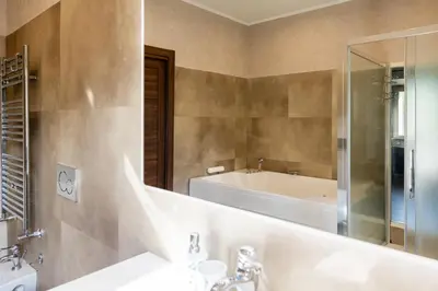 a bathroom with a tub and a sink and a mirror at Caffarella Suite in Rome